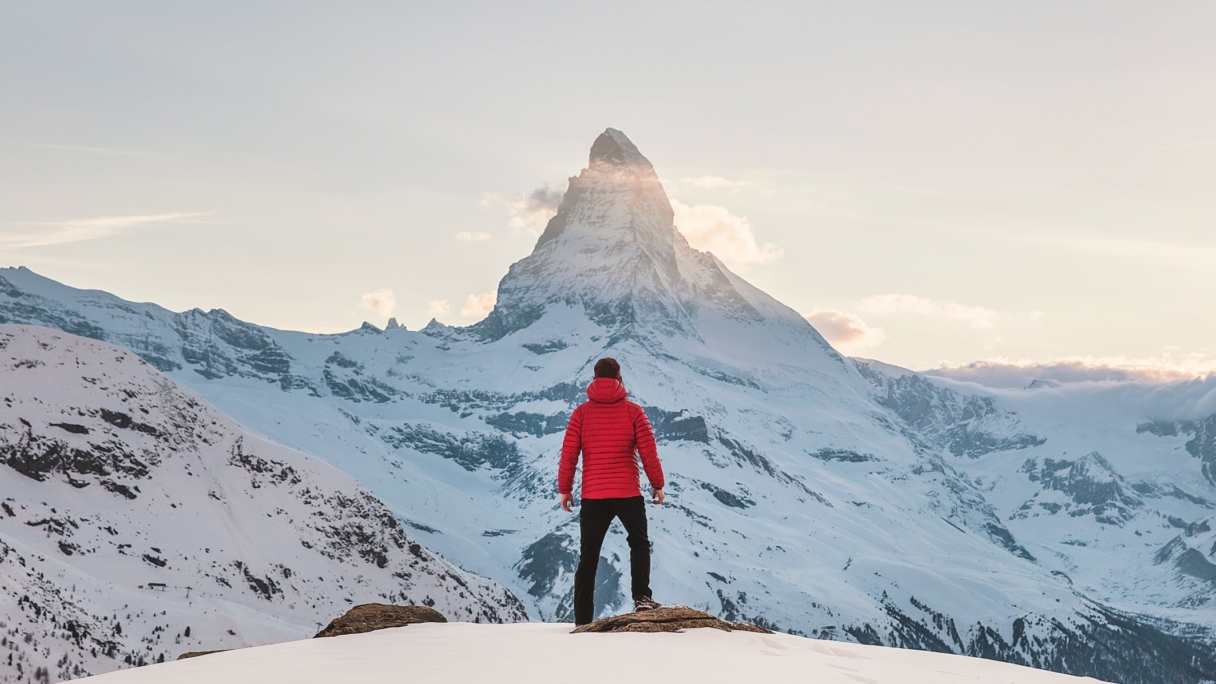 Man at the top of a snowy mountain peak